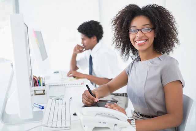 woman and man smiling at their desk
